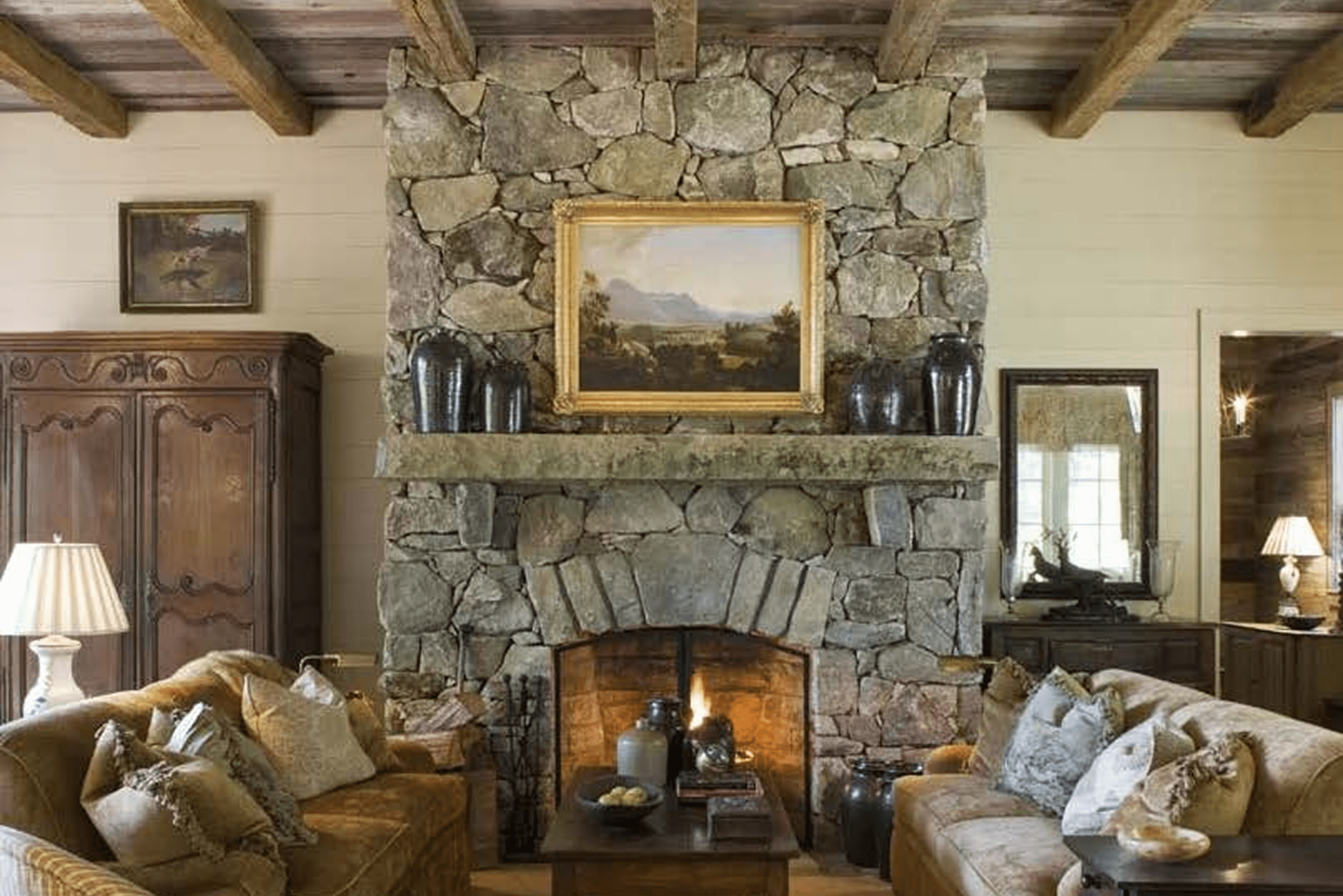 Cozy living room with stone fireplace and rustic decor.